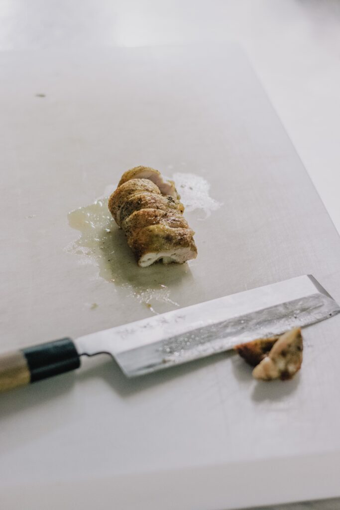 Trozos de pollo completamente cocidos sobre una tabla de cocina